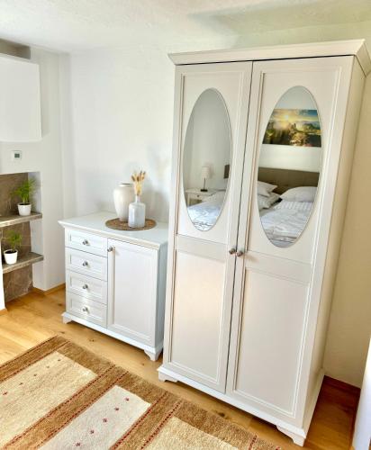 a white cabinet with a mirror in a bedroom at Haus Landzauber in Ramsau am Dachstein
