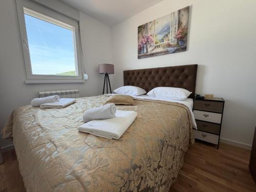 a bedroom with a large bed with towels on it at Apartment Alto in Sarajevo