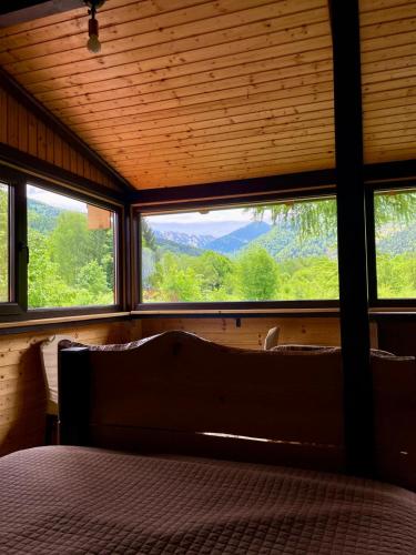a bedroom with a bed and windows with a view at Alpinlife in Dejani
