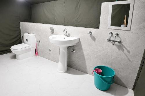 a bathroom with a sink and a toilet and a mirror at Snowpeak Retreat in Hundar