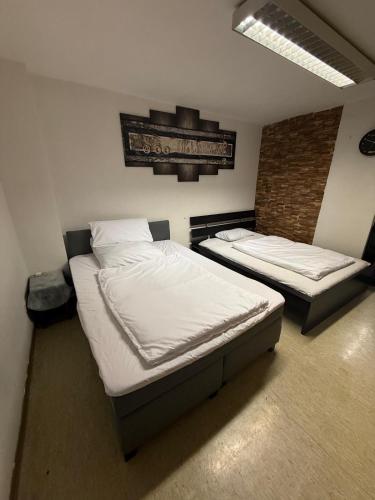 a bedroom with two beds and a brick wall at Ferienwohnung Adenau in Adenau
