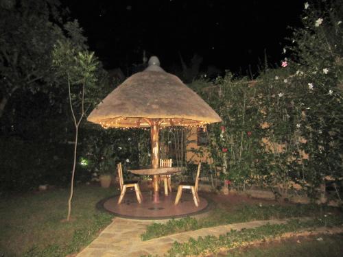 a table and two chairs under an umbrella at Precious Guesthouse in Entebbe
