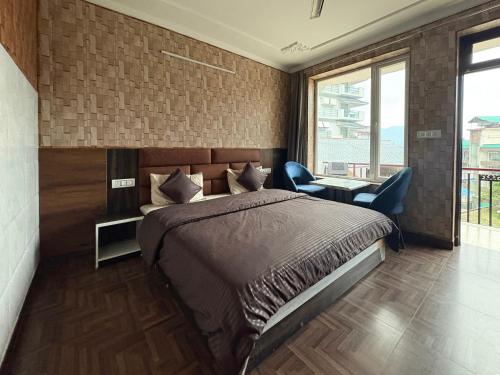 a bedroom with a bed and a desk and a window at Young Monk Hostel Bhagsu,Mcleodganj in Dharamshala