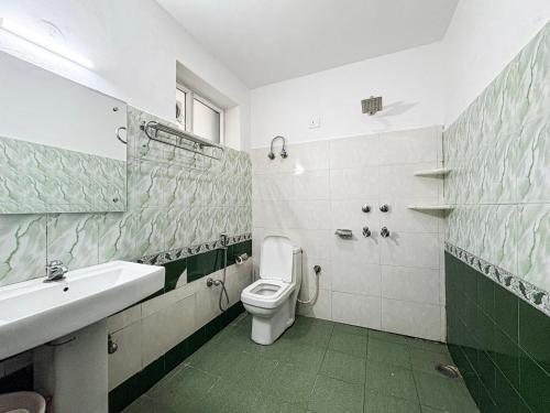 a bathroom with a toilet and a sink at Young Monk Hostel Bhagsu,Mcleodganj in Dharamshala