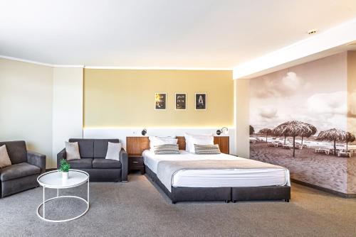 ein Hotelzimmer mit einem Bett und einer Couch in der Unterkunft Hotel NOBEL Ultra All Inclusive - FREE Beach Access in Sonnenstrand