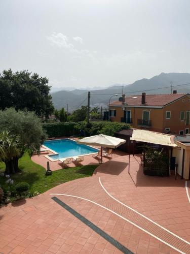 a swimming pool with umbrellas and a house at B&B LA ROSA in Salerno