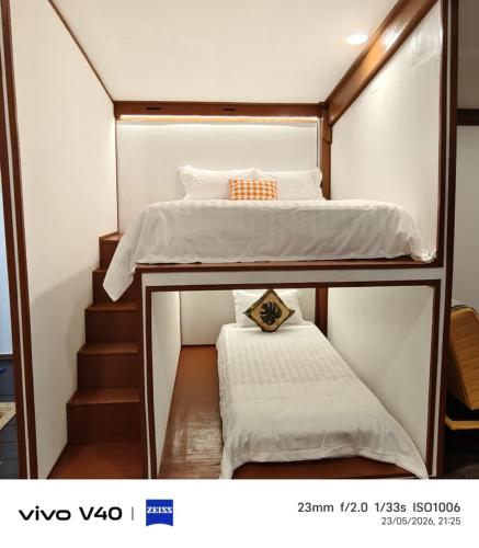 a small bedroom with two bunk beds and stairs at Ciao Bella in Dungun