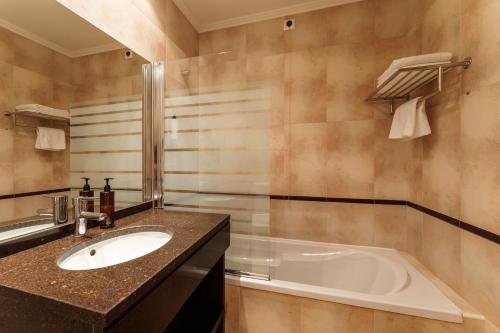 a bathroom with a sink and a bath tub at Made Inn Entroncamento in Entroncamento