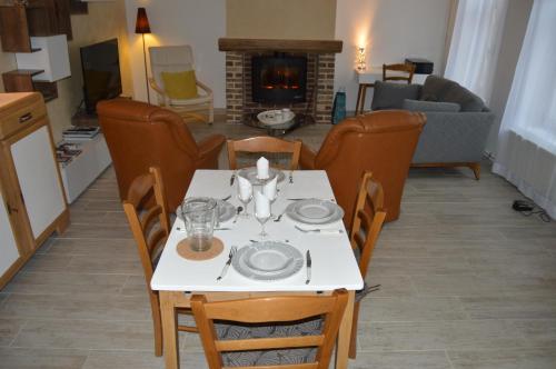 a dining table and chairs in a living room with a fireplace at Au Coeur d'Amiens in Amiens