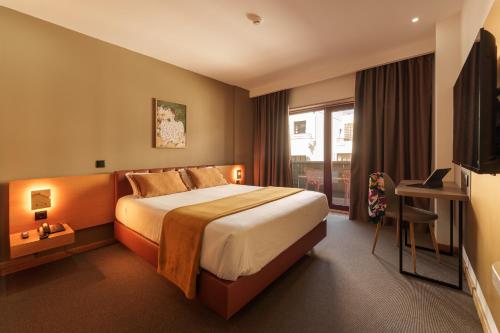 a hotel room with a bed and a window at Made Inn Entroncamento in Entroncamento
