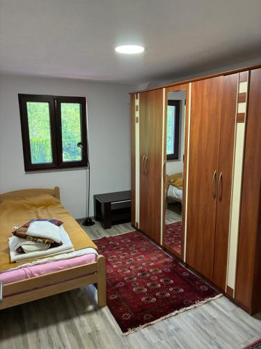 a bedroom with a bed and a wardrobe and a rug at Holiday House Ostrozac na Uni in Ostrožac