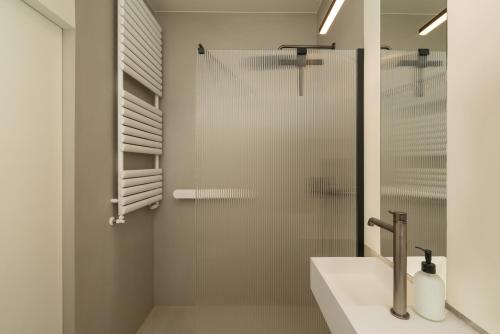 a shower with a glass door next to a sink at apartamenty-wroc Central Park in Wrocław