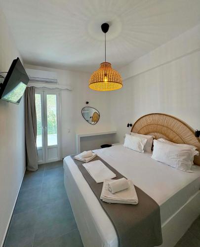 a bedroom with a large white bed and a chandelier at Maria's Garden in Antiparos
