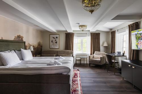 a hotel room with a large bed and a desk at Söderfors Herrgård in Söderfors