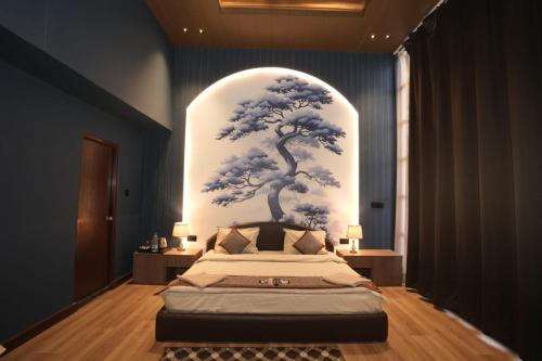 a bedroom with a bed with a tree mural on the wall at L'Elegant Resort in Chail