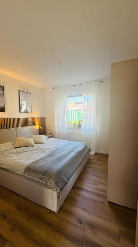 a bedroom with a large bed and a window at Nord Loft in Langeoog