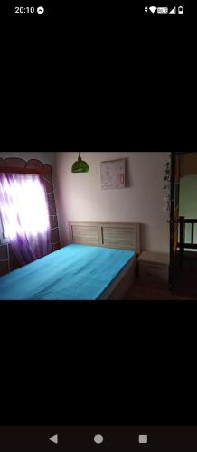 a bedroom with a bed with blue sheets and a window at Aegean View in Agios Kirykos