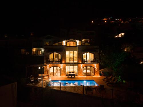 a large house with a swimming pool at night at Villa Meltem in Kalkan
