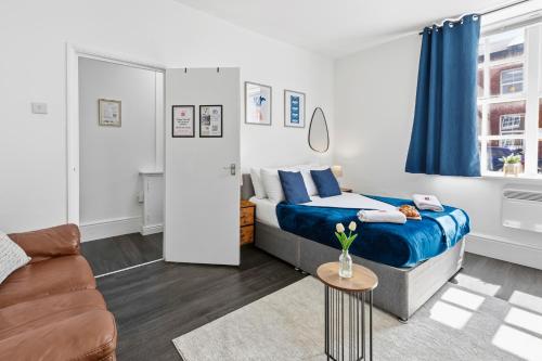 a small bedroom with a bed and a couch at Tigris - Cosy Studio Apartment by Traboule Properties Ltd in Warrington