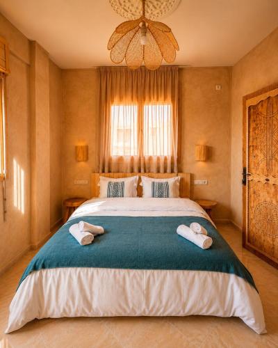 a bedroom with a large bed with two towels on it at Yara Lodge in Tamraght Ou Fella