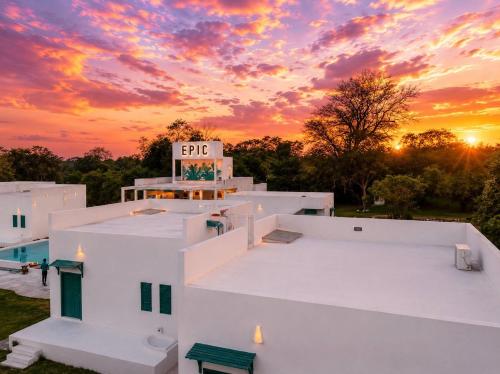 a sunset over a white building with a sign on it at Epic Wild Wilpattu in Nochchiyagama