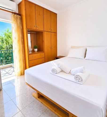 a bedroom with a large white bed with towels on it at Olga Apartments in Kolónion