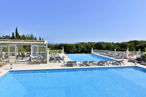 une grande piscine avec des chaises longues dans l'établissement Le Mas Bellevue, à Saint-Tropez