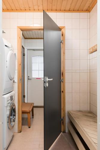 a door in a bathroom with a washing machine at CYV - A unique Villa on a Lake in Jämijärvi