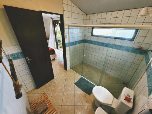 a bathroom with a toilet and a glass shower at Pousada Ilha do Frade in Fernando de Noronha