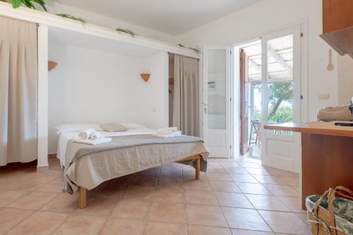 a bedroom with a bed in a room with a kitchen at Borgo del Sole Salento in Torre Vado