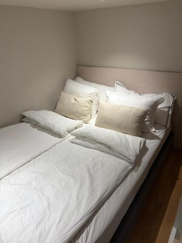 a white bed with white sheets and pillows on it at Studio apartment in Sogndal