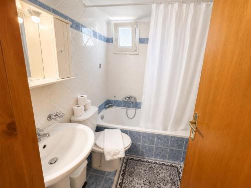 a bathroom with a sink and a toilet and a shower at Olga Apartments in Kolónion