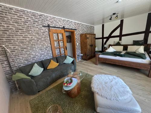 a living room with a couch and a brick wall at Ferienwohnung Puschel in Salzhemmendorf