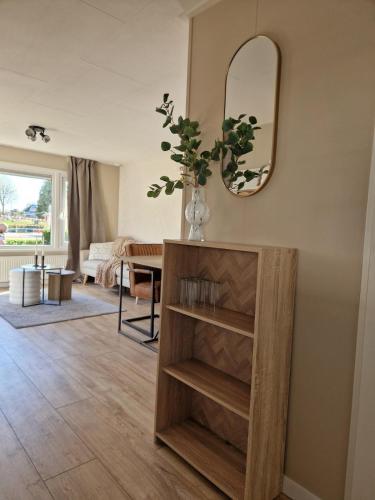a living room with a table and a mirror at Chalet in Berkhout, close to the beach in Berkhout