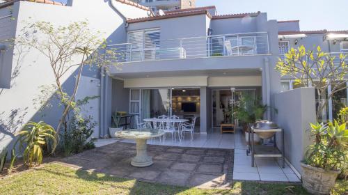 a house with a balcony with a table in the yard at D3 Sea Lodge - by Stay in Umhlanga in Durban