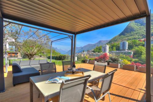 a patio with a table and chairs on a wooden deck at Lugano Lake View Villa with Private Pool in Lugano