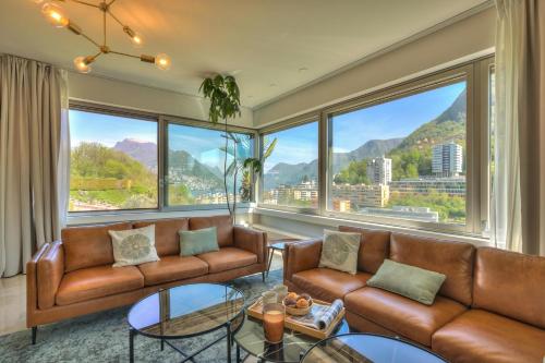 a living room with leather furniture and large windows at Lugano Lake View Villa with Private Pool in Lugano