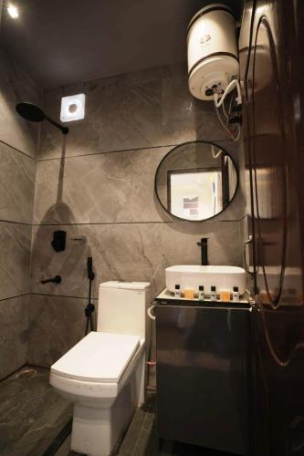 a bathroom with a toilet and a sink and a mirror at L'Elegant Resort in Chail