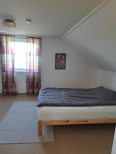 a bedroom with a bed in a room with a window at Bright and spacious home with good in Klepp