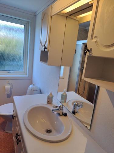 a bathroom with a sink and a mirror at Bright and spacious home with good in Klepp