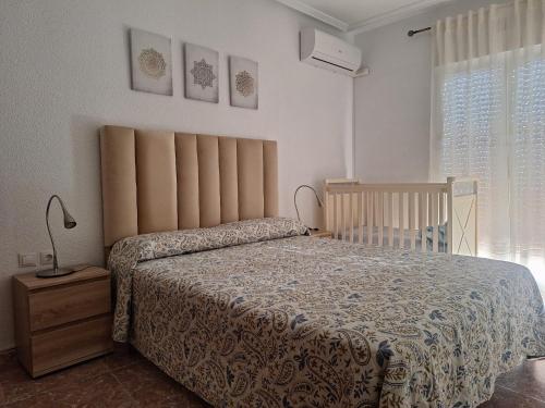 a bedroom with a bed and a crib at Apartamento Sevilla 3 in La Guardia