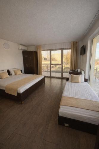 a hotel room with two beds and a large window at Vila Rubin in Eforie Nord