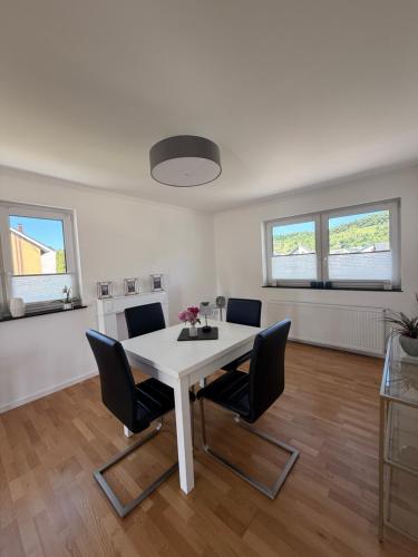 a white dining room with a white table and chairs at Ferienwohnung Auszeit Langsur in Langsur