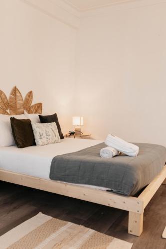a bed with a wooden frame in a bedroom at Aurega Vintage Bedrooms by Lethes Legacy in Ponte de Lima