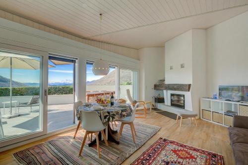 a dining room with a table and a view of the mountains at La Cà Da Brè - Garden House with Views - Happy Rentals in Lugano