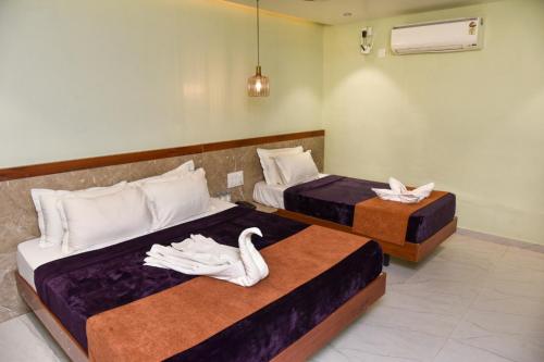 two beds with swans on them in a room at Shri Guru Prasad in Belgaum