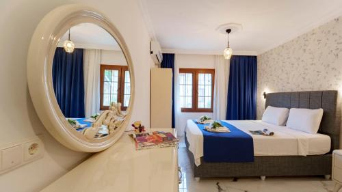 a bedroom with a large mirror and a bed at Flower Apart 2 - Flower Hotel Patara in Gelemiş