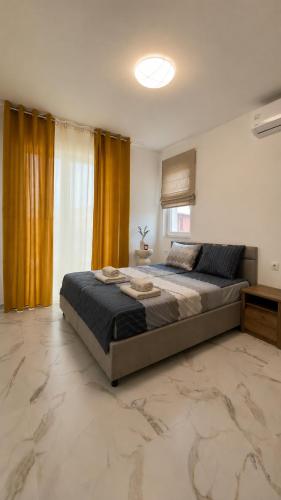 a bedroom with a large bed with yellow curtains at Blu Riviera Deluxe in Ahtopol