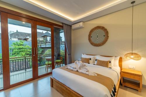 a bedroom with a bed and a balcony at Pondok Tis Bisma in Ubud