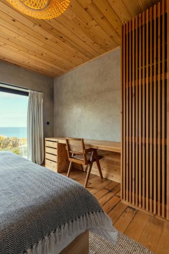 a bedroom with a bed and a desk and a window at Casa da Figueira in São Roque do Pico